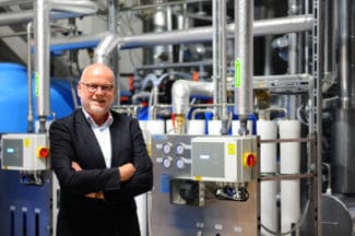 Herma-Geschäftsführer Dr. Thomas Baumgärtner vor der neuen dezentralen Dampferzeugungsanlage