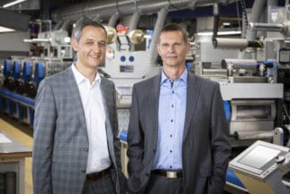 Die Carini-Geschäftsleitung vor einer der Druckmaschinen: Edgar Sohm (l.) MBA und Dr.-Ing. Harald Raak (Quelle: Carini)