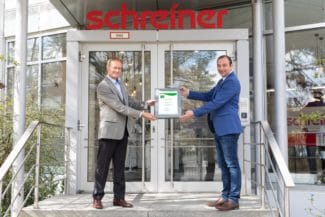 Oberschleißheims Bürgermeister Markus Böck freut sich, die Urkunde für den Umwelt- und Klimapakt Bayern an den Leiter des Umweltschutzmanagements bei der Schreiner Group, Dr. Thomas Gulden, zu übergeben (Quelle: Schreiner Group)