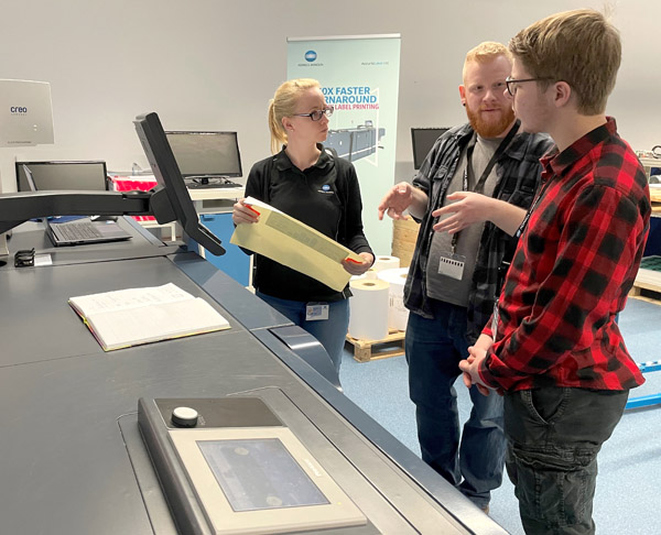 Laura Marie Bachl (l.), Konica Minolta Europe mit Alexander Hellmundt und dem Bediener der neuen AL230, Leon Gerstenhauser von BohnEtiketten bei der FAT in Langenhagen (Quelle: Nilpeter GmbH)