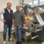 Andreas Nies, Typographus GmbH (r.) und Sven Rauchfuss, Nilpeter GmbH vor der neuen GM330Mini (Quelle: Nilpeter)