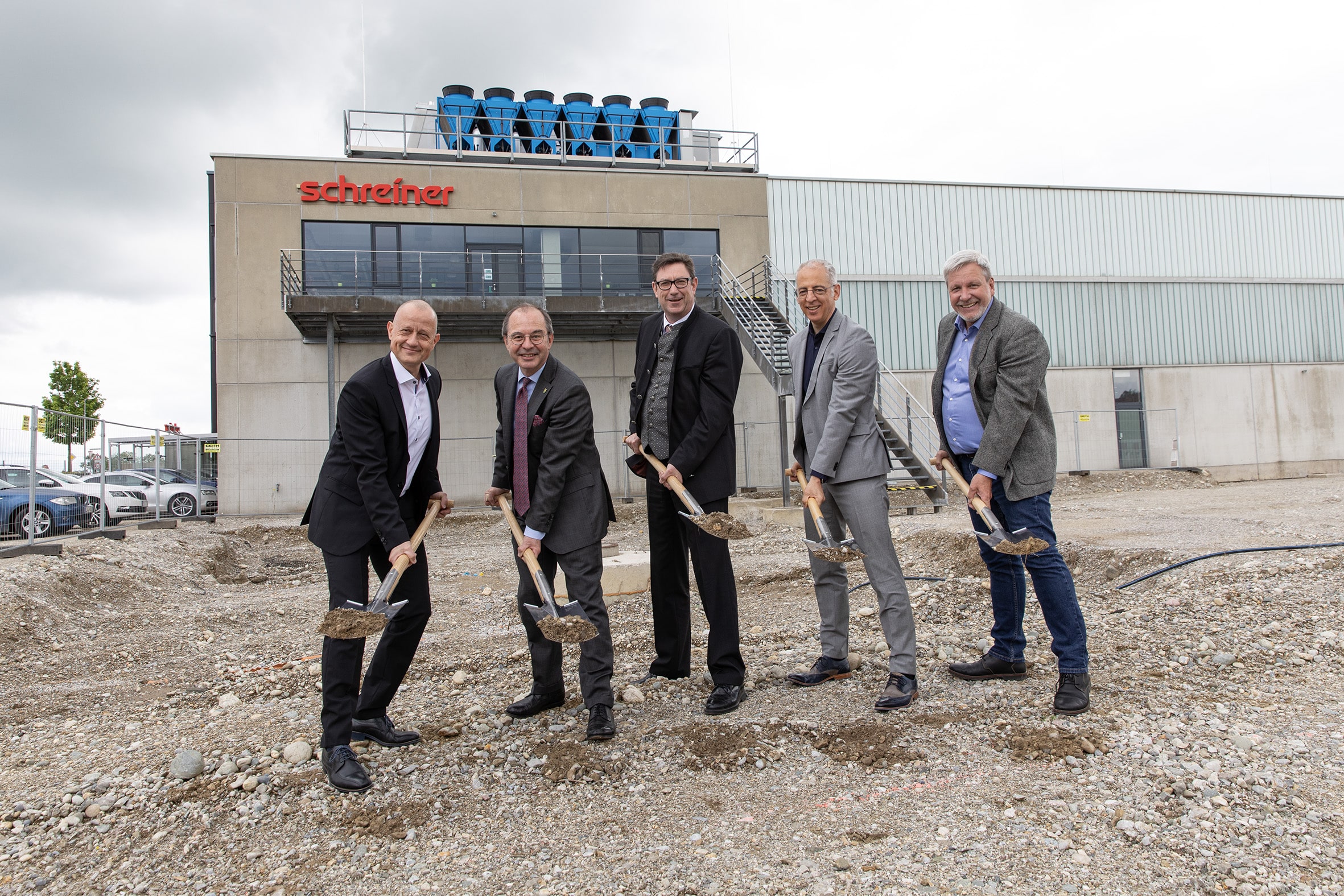 Der Anbau am Dorfener Werk der Schreiner Group startet: Geschäftsführer Roland Schreiner (2.v.r.) setzt zusammen mit dem Werksleiter Erich Pably (l.), dem Leiter Facility Management Wolfgang Bonnet (r.), dem Erdinger Landrat Martin Bayerstorfer (Mitte) und dem Dorfener Bürgermeister Heinz Grundner (2.v.l.) den ersten Spatenstich.