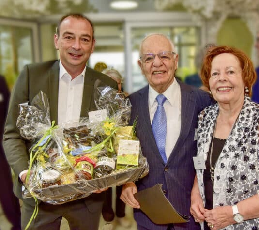 Oberschleißheims Bürgermeister Markus Böck (links) gratulierte Helmut Schreiner mit einem Geschenke-Korb der Gemeinde zum 85. Geburtstag. Der Jubilar ist mit Ehefrau Ulrike (rechts) seit fast 60 Jahren verheiratet (Quelle: Schreiner Group)