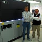 Thomas Wirkotsch, Etisys-Geschäftsführer (links) und Klaus Sedlmayr, Chromos Deutschland GmbH, vor der Durst Tau G3 (Quelle: Klemens Ehrlitzer)