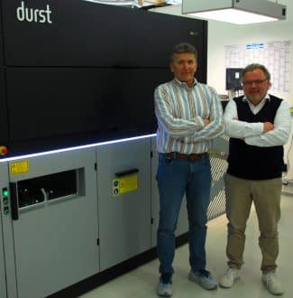 Thomas Wirkotsch, Etisys-Geschäftsführer (links) und Klaus Sedlmayr, Chromos Deutschland GmbH, vor der Durst Tau G3 (Quelle: Klemens Ehrlitzer)