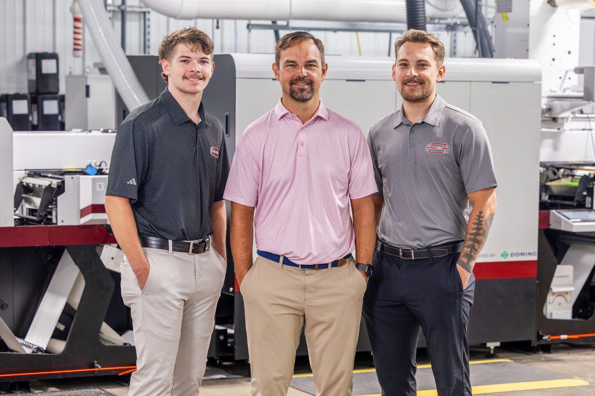 V.l.: Simon Hicks, Joey Hicks und Silas Hicks vor der neuen Mark Andy DSiQ bei PrintCo360 (Quelle: Mark Andy)